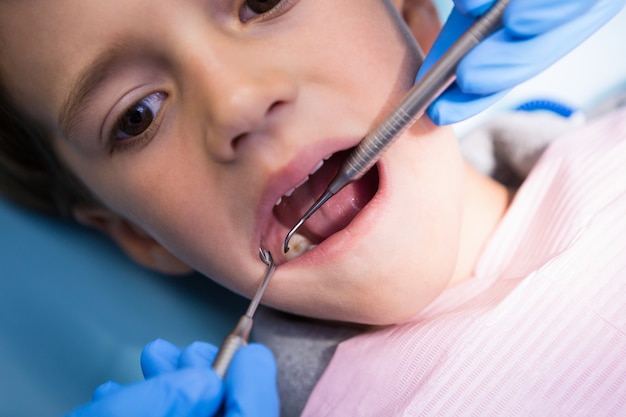 Dentista dando tratamiento al niño en la clínica médica