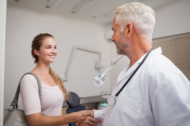 Dentista dándole la mano a su paciente