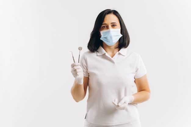 Dentista de mulher em uma máscara médica mostra algo em um espaço de cópia