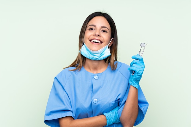 Dentista de mulher segurando ferramentas rindo