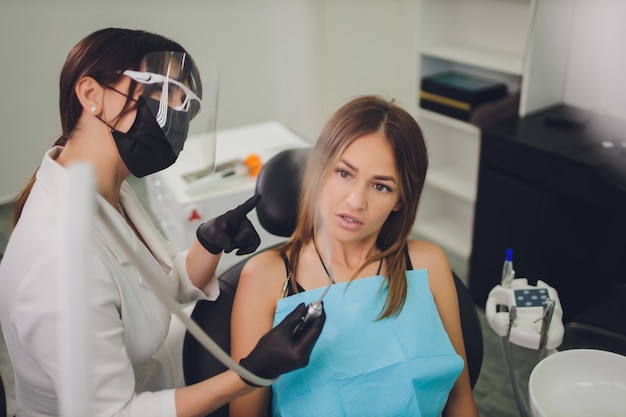 El dentista detecta los dientes cariados del paciente en la silla del dentista.