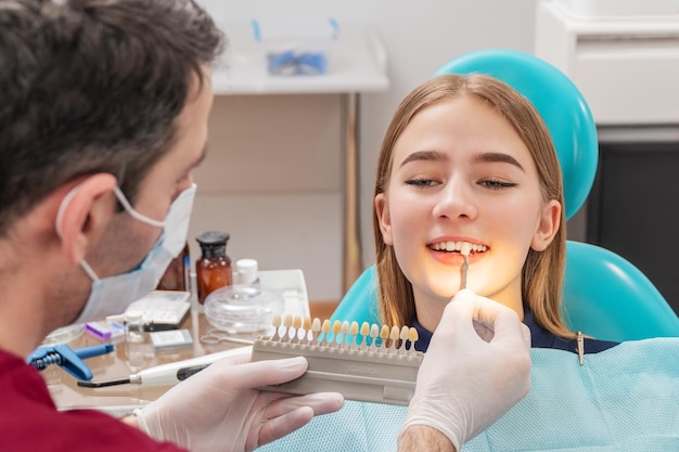 el dentista determina el color de los dientes del paciente usando sondas