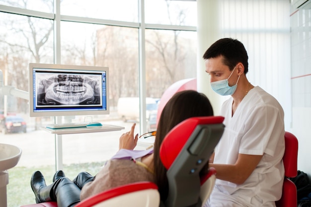 El dentista le dice al paciente sobre el estado de los dientes.