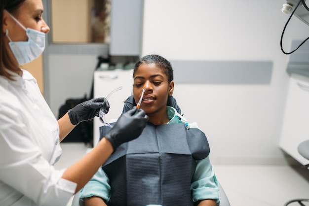 Dentista e mulher, visita clínica odontológica