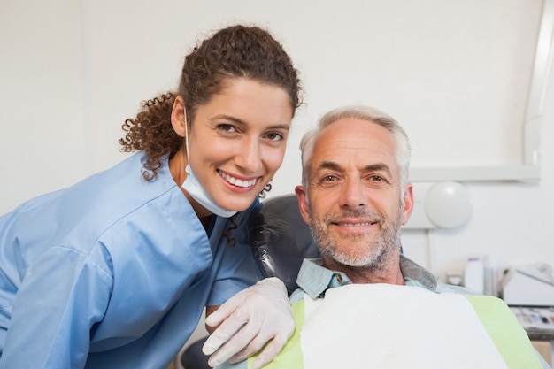 Foto dentista e paciente sorrindo para a câmera