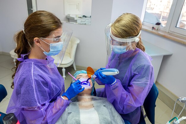 El dentista se encuentra en una silla especial donde el dentista y el asistente realizarán un blanqueamiento dental