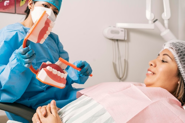 Dentista ensinando como limpar a boca usando para um paciente usando um protótipo