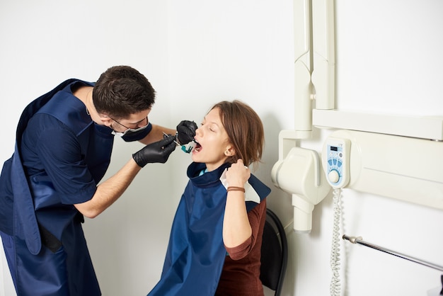 El dentista está curando al paciente haciendo una radiografía en el consultorio dental