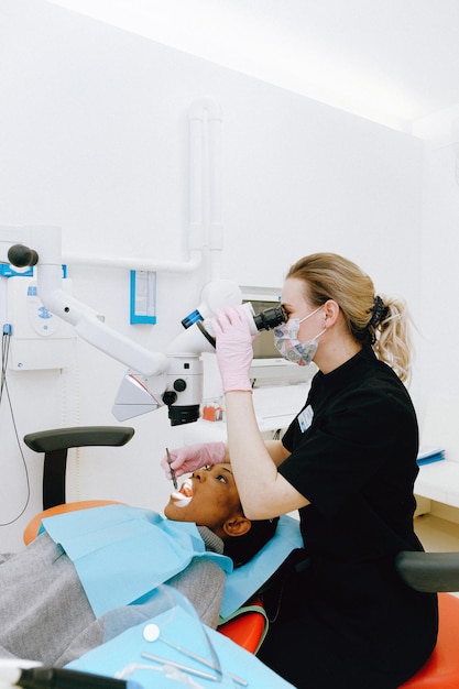 Un dentista está mirando los dientes de un paciente.