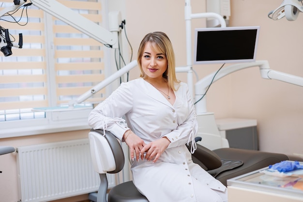 El dentista está en su consultorio dental Mujer dentista con bata blanca Consultorio dental