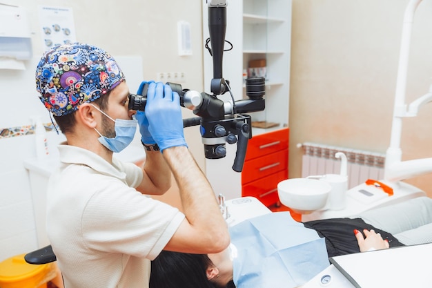 El dentista examina la boca del paciente con un microscopio dental tratamiento dental el concepto de microscopio de dientes sanos en odontología