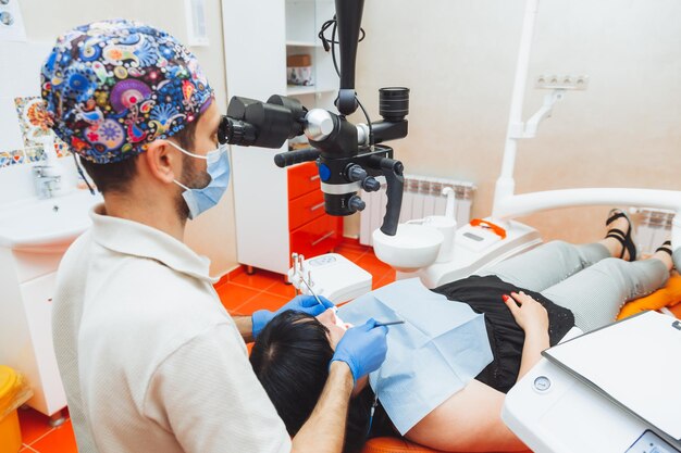 El dentista examina la boca del paciente con un microscopio dental tratamiento dental el concepto de microscopio de dientes sanos en odontología