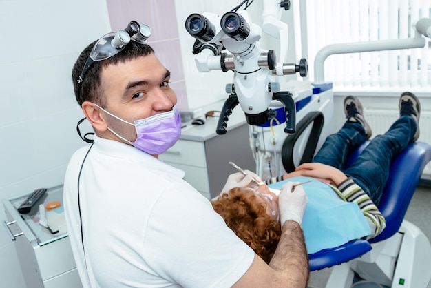 El dentista examina los dientes bajo el microscopio.