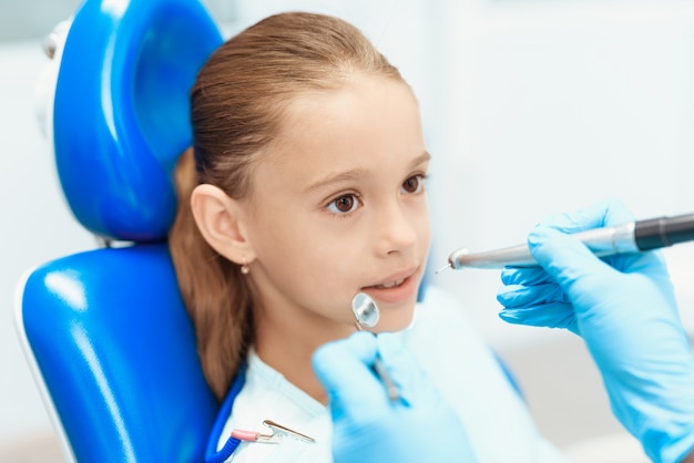 El dentista examina los dientes de la niña. Cuidado dental del diente.