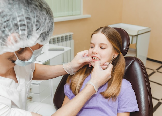 El dentista examina los dientes del niño en el concepto de medicina y odontología de la silla dental