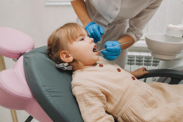 El dentista examina los dientes del niño en el sillón dental. concepto de medicina y odontología.