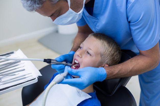 Dentista examina a un paciente joven con herramientas