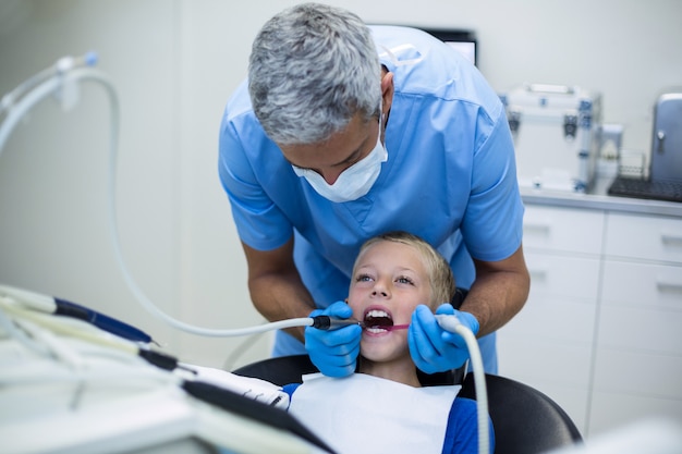 Dentista examina a un paciente joven con herramientas