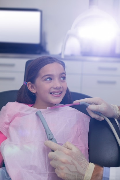 Dentista examina a un paciente joven con herramientas