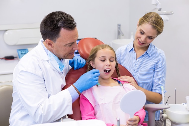 Dentista examina a un paciente joven con herramientas