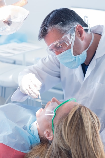 Dentista examinando dentes de pacientes na cadeira de dentistas