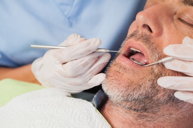 Dentista examinando dentes de pacientes na cadeira de dentistas