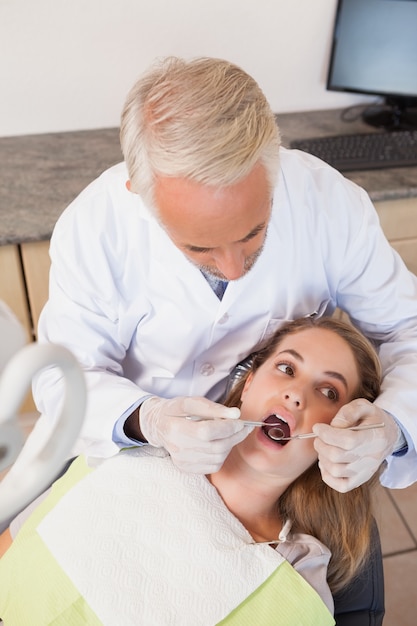 Dentista examinando dentes de pacientes na cadeira de dentistas