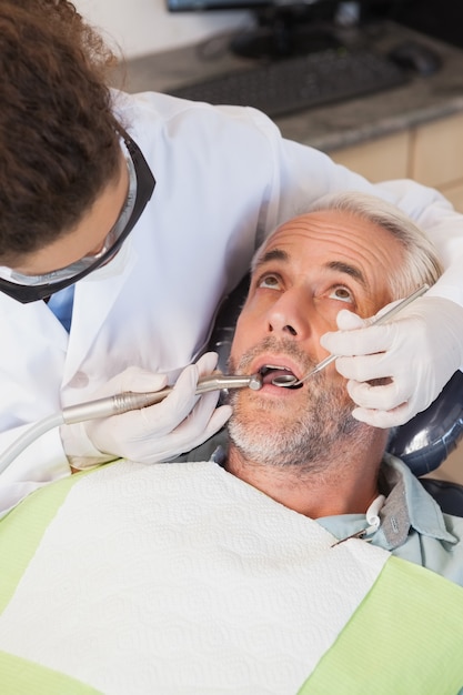 Dentista examinando dentes de pacientes na cadeira de dentistas