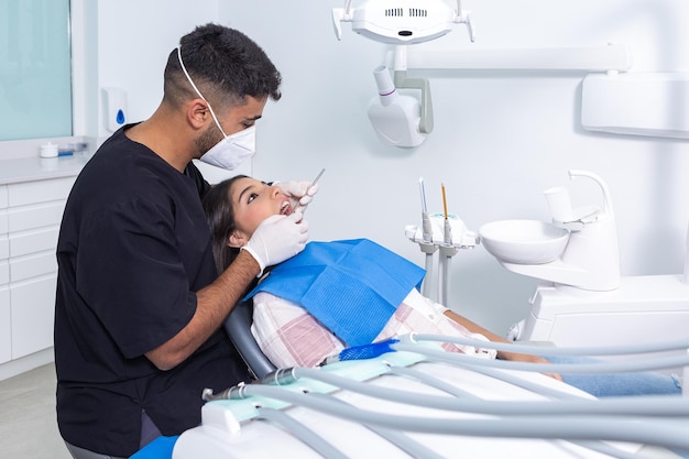 Dentista examinando dientes de adolescente