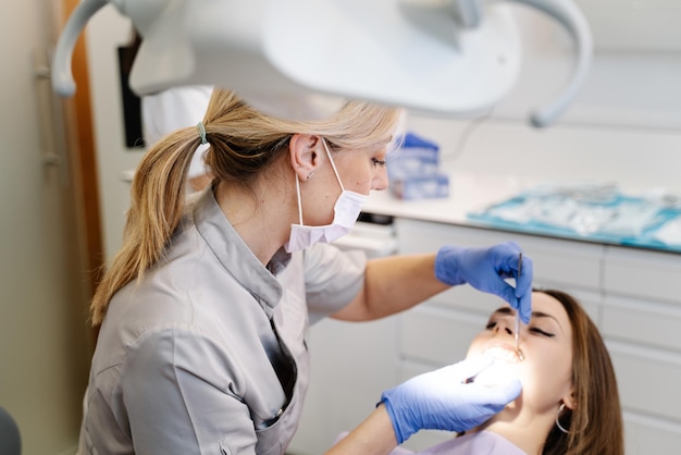 Dentista examinando dientes de mujer