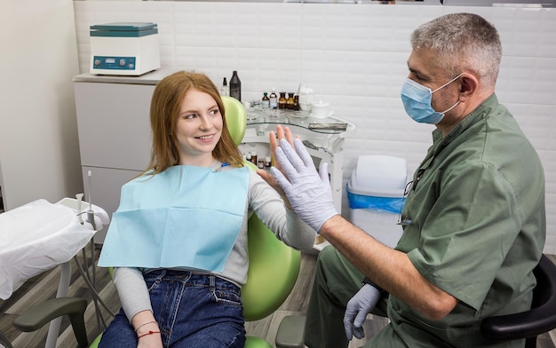 Foto dentista examinando los dientes de la niña en la clínica problema dental sonrisa saludable