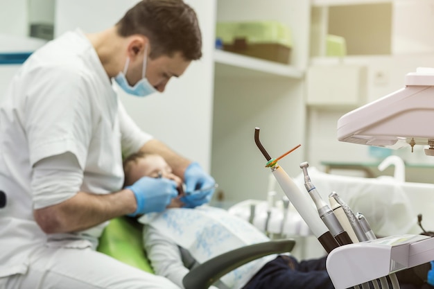 Dentista examinando los dientes de un niño pequeño en la clínica Problema dental