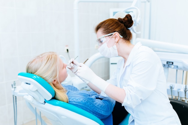 Dentista examinando los dientes de un paciente en la clínica.