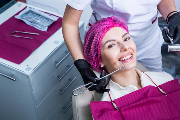 Dentista examinando los dientes de una paciente joven en una clínica dental Concepto de odontología