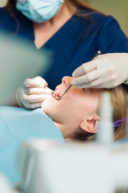 Dentista examinando menina na clínica