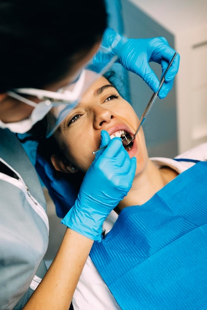 Foto dentista examinando a una mujer en la clínica