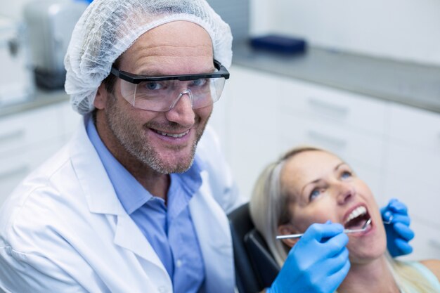 Dentista examinando a una mujer con herramientas