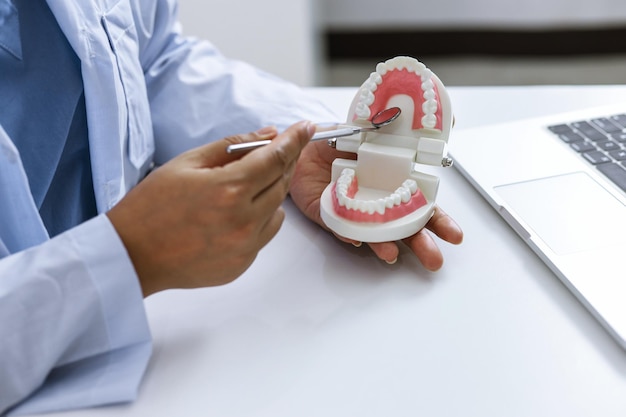 Foto dentista examinando o tratamento médico dos dentes de um paciente na clínica odontológica