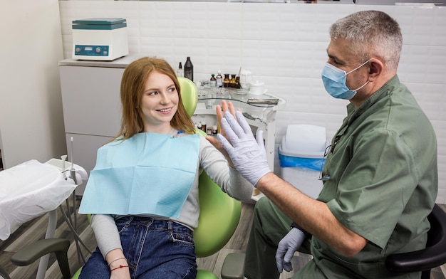 Dentista examinando os dentes da menina na clínica Problema dentário Sorriso saudável