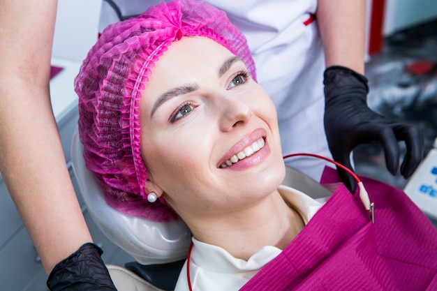 Dentista examinando os dentes de uma jovem paciente em uma clínica dentária Conceito de odontologia