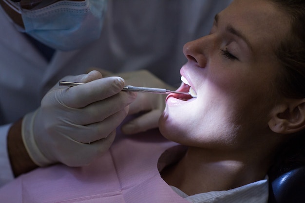 Dentista examinando a un paciente con herramientas