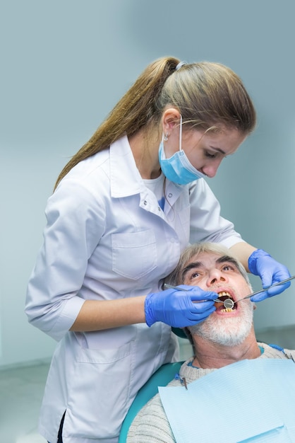 Dentista examinando paciente senior