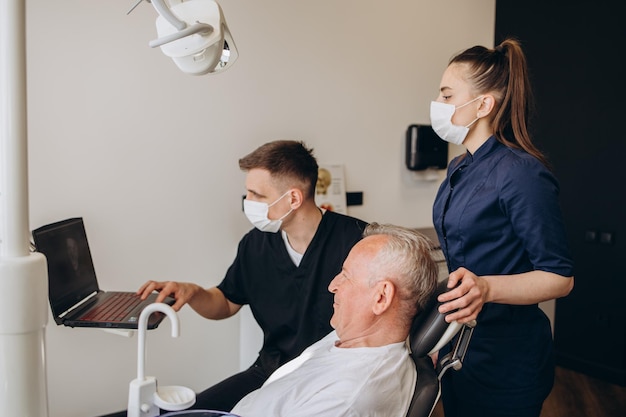 Dentista examinando rayos X dentales de ancianos mayores