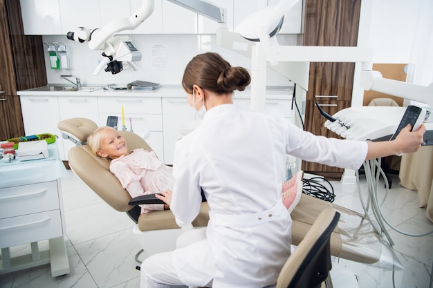 Dentista experto examina los dientes de un niño