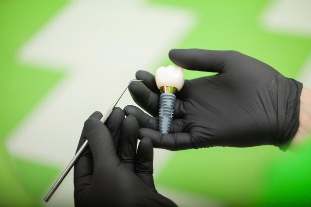 Dentista, explicando o modelo de dentes para paciente do sexo feminino. Fotos técnicas em um laboratório de prótese dentária