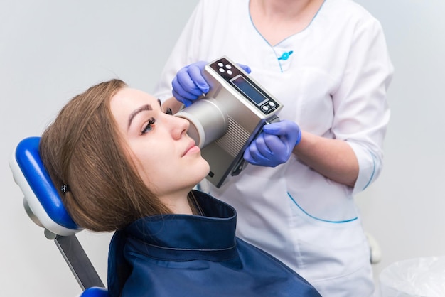 Dentista faz imagem de raio-x da mandíbula para menina na clínica odontológica