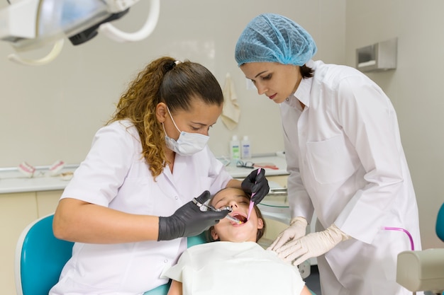 Dentista faz injeção anestésica na gengiva