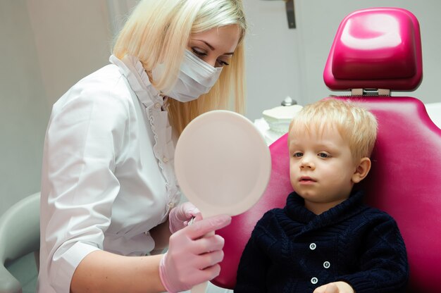 Dentista, fazendo check-up dentário regular para menino.