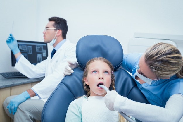 Dentista femenino, examinar, niñas, dientes