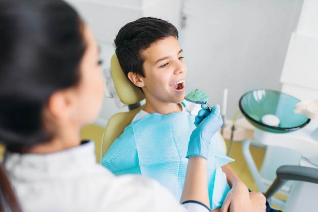 Dentista femenino con pasta para impresión de dientes